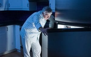Senior man looking in refrigerator at night   Original Filename: 73032480.jpg
